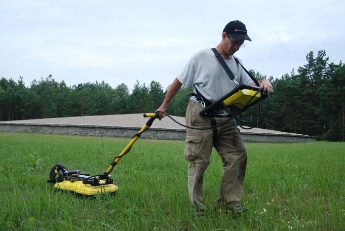Researcher pushing ground-penetrating radar equipment across the Sobibor site.
