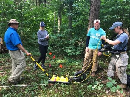 Research team collecting ground-penetrating radar data at the suspected Matilda Olkin burial site in the forest.