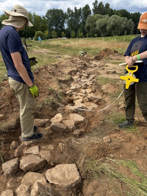 Completed 2026 excavation exposing stones and concrete identified as remains of the Jungfernhof prisoner barracks.