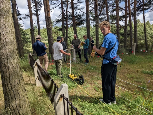 Researchers collecting ground-penetrating radar data beside the Soviet-era monument in the Skede dunes.