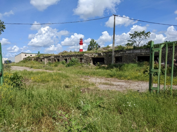 Modern 2022 photograph taken from approximately the same perspective as the Wiener-film still, with the Liepaja Lighthouse and fortification visible.